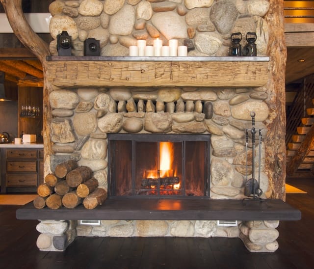 A fireplace surrounded by large stones in a home.